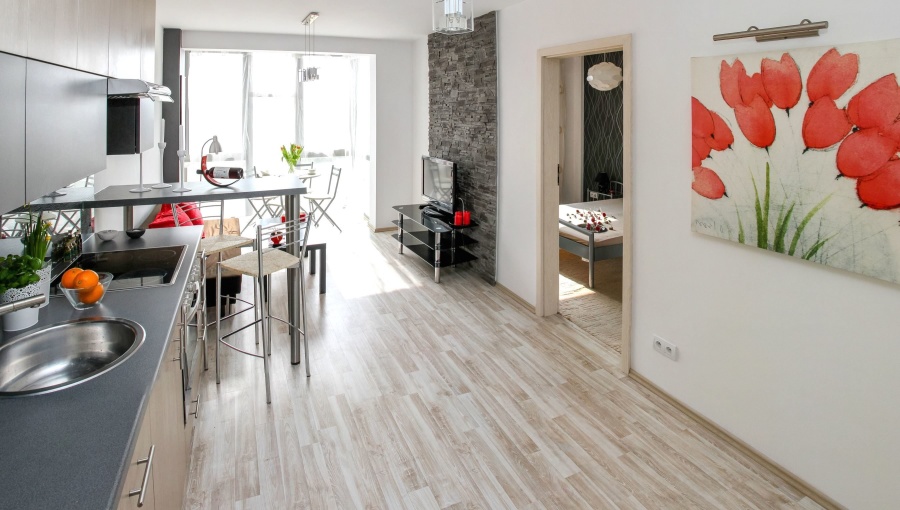 A furnished kitchen and dining space with a visible hard floor and chair legs