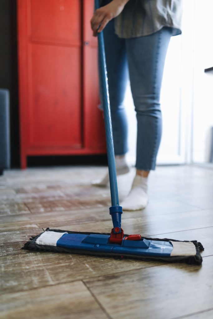 A person using a flat mop on a residential floor.